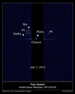 Die fünf Monde des Pluto. Der neu entdeckte Mond P5 ist grün markiert. Die äußeren Bildbereiche sind stärker belichtet.