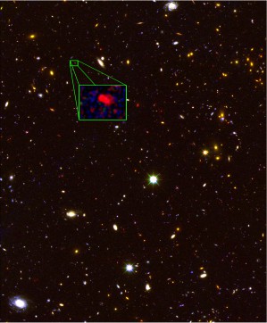 Diese Aufnahme des Weltraumteleskops Hubble zeigt die älteste spektroskopisch bestimmte Galaxie, vergrößert dargestellt im Kasten. Fast alle weiteren Objekte auf dieser Aufnahme sind ebenfalls Galaxien.