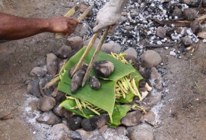Mitglieder eines Stammes in Papua-Neuguinea bereiten eine Mahlzeit.