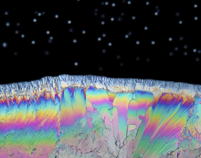 Aus der Kategorie „Lobende Erwähnungen“ im Wettbewerb „BMC ‚Research in Progress‘ Photo Competition“ stammt das Foto „Night Sky on Planet Acetaminophen“ von Karl Gaff: die Aufnahme einer dünnen Schicht der als Medikament verwendeten Substanz Para-(Acetylamino)phenol mit Hilfe eines Polarisationsmikroskops. Die „Sterne“ im Hintergrund sind kleine Wassertröpfchen. (Blog: http://blogs.biomedcentral.com/bmcblog/2017/09/29/bmc-research-in-progress-photo-competition-the-winning-images/.