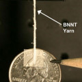 Am Faden aus Bor-Nitrid-Nanoröhrchen hängt ein Vierteldollar