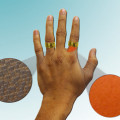 Eine Illustration der Forscher zeigt, wie die Nanopartikelcreme am Ringfinger vor dem im Ring enthaltenen Nickel schützen würde, während sich am ungeschützten Zeigefinger eine allergische Reaktion zeigt