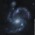 Die Galaxie BX442 mit ihrem Begleiter, einer Zwerggalaxie (links oben). Die kleine Galaxie könnte der großen zu ihrer Spiralform verholfen haben.