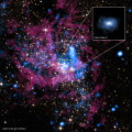 Dieses Bild zeigt die Region um Sagittarius A *, das Supermassereiche Schwarze Loch im Zentrum unserer Milchstraße. Mit dem Chandra-Teleskop aufgenommene Röntgenstrahlung ist blau dargestellt, mit dem Hubble-Teleskop aufgenommene Infrarotstrahlung violett und gelb. Im Kasten rechts oben ist eine vergrößerte Aufnahme des Schwarzen Loches zu sehen, die einen Bereich von einem halben Lichtjahr abdeckt.