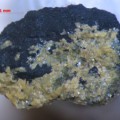 Kleine Stepanovit-Kristalle auf einem Kohlestückchen